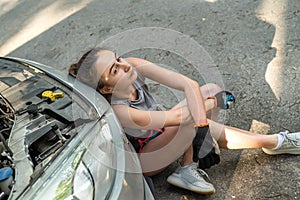 fragile beautiful girl smeared with oil with many tools in her hands repairs the car.