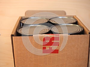 Fragile cardboard box with tin cans