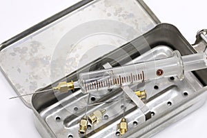 fragile old glass syringe and the vintage metal case