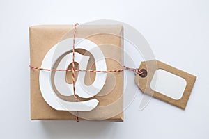 Fragile parcel wrapped in brown paper with e-mail wooden sign and label against white background