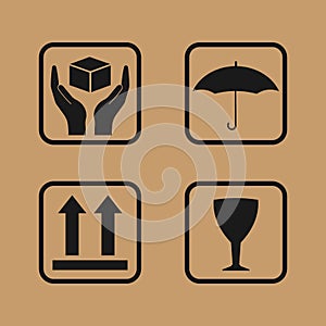Fragile symbol on cardboard. Set of fragile icons on cardboard. Umbrella,glass, arrow and hands box signs photo