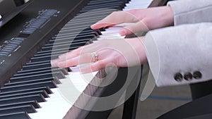 Fragile tender female hands playing a synthesizer outside in the cold season