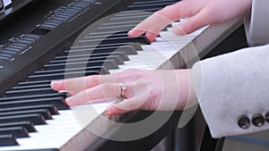 Fragile tender female hands playing a synthesizer outside in the cold season