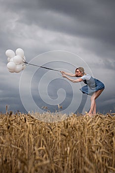 Fragile Woman Keeps Balloons Against Strong Wind