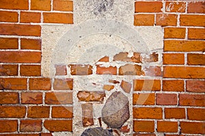Fragment of ancient red brick wall with stones