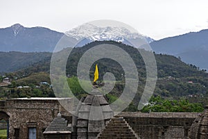 Fragment of ancient Shiva temple at Baijnath, Himachal Pradesh, India with green hills and snowy mountains in the backdrop