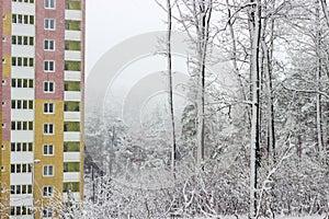 Fragment of apartment building on background of forest during sn