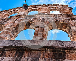Fragment of the Arena di Verona against a background of blue sky with white clouds.