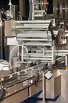 Fragment of an automatic packaging line with roller guides at a food factory