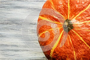 Fragment of autumn orange pumpkin close-up on a gray wooden background on a table top view flatlay with copy space, healthy food