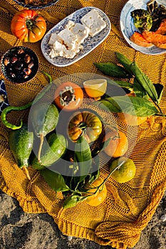 Fragment of an autumn picnic with tomatoes, avocadors, cheese, olives