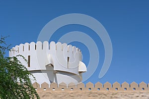 Fragment of bastion fort wall and part of watchtower in Abu Dhabi,UAE. Defensive middle eastern city wall with prongs.