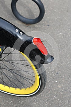 Fragment of a bicycle wheel. With a yellow rim. Stop signal is red