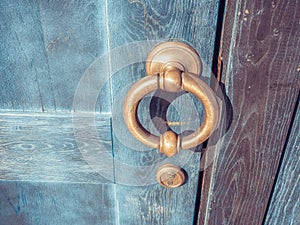 Fragment of a blue wooden door with a golden round door handle