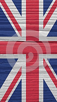 Fragment of British flag on a dry wooden surface. Natural vertical background. Mobile phone wallpaper made of old wood. The