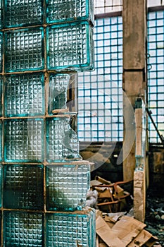 Fragment of broken wall from glass blocks in abandoned industrial building