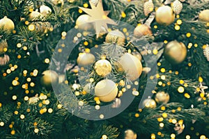 Fragment close up of a decorated christmas tree with golden balls. Winter holiday background