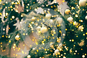 Fragment close up of a decorated christmas tree with golden balls. Winter holiday background