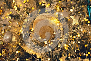 Fragment close up of a decorated christmas tree with golden balls. Winter holiday background