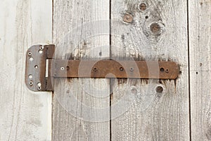 Fragment of closed old wooden gate with rusty hinges