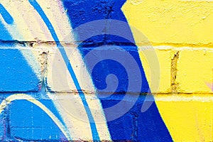 A fragment of colorful graffiti painted on a brick wall. Abstract backdrop for design