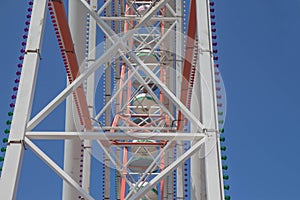 Fragment A colourful ferris wheel. Brightly colored Ferris wheel against the blue sky