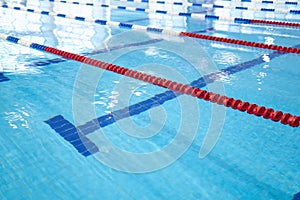 Fragment of the competition pool with blue water and marked swimming lanes