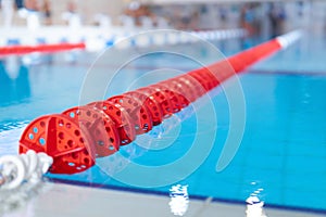 Fragment of the competition pool with blue water and marked swimming lanes