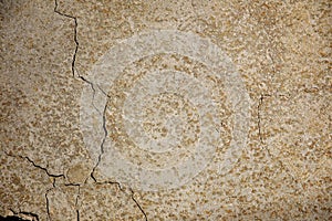 A fragment of a concrete wall with cracks and plaster defects, texture