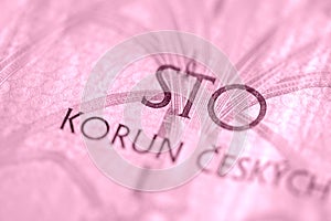 Fragment of a Czech banknote in one hundred crowns closeup. Money background pink color toned