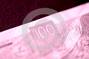 Fragment of a Czech banknote in one hundred crowns closeup. Money background pink color toned