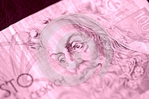 Fragment of a Czech banknote in one hundred crowns closeup. Money background pink color toned