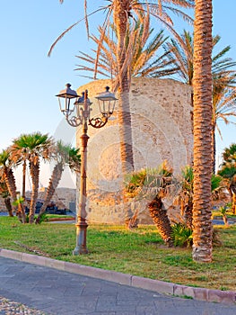 Fragment of defensive walls and palm trees in Alghero. Sardinia, Italy