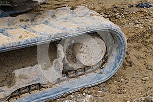 Fragment of a dirty caterpillar of a excavator at a construction site