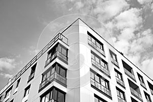 Fragment of a facade of a building with windows and balconies. Black and white.