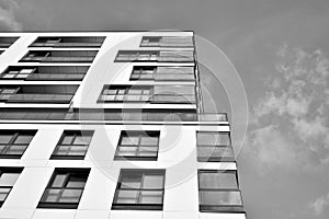 Fragment of a facade of a building with windows and balconies. Black and white.