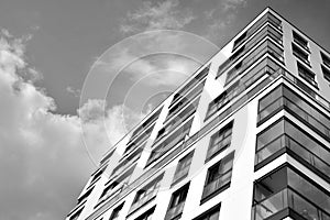 Fragment of a facade of a building with windows and balconies. Black and white.