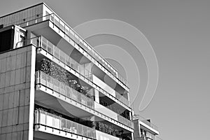 Fragment of a facade of a building with windows and balconies. Black and white.