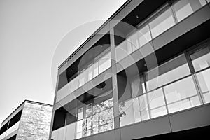 Fragment of a facade of a building with windows and balconies. Black and white.