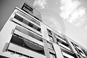 Fragment of a facade of a building with windows and balconies. Black and white.