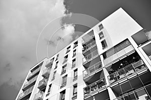 Fragment of a facade of a building with windows and balconies. Black and white.