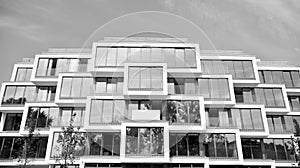 Fragment of a facade of a building with windows and balconies. Black and white.