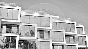 Fragment of a facade of a building with windows and balconies. Black and white.