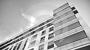 Fragment of a facade of a building with windows and balconies. Black and white.