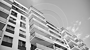 Fragment of a facade of a building with windows and balconies. Black and white.