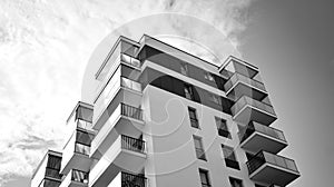 Fragment of a facade of a building with windows and balconies. Black and white.