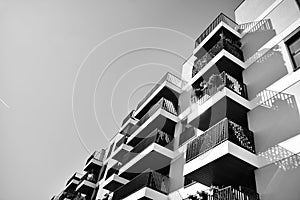 Fragment of a facade of a building with windows and balconies. Black and white.