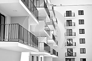 Fragment of a facade of a building with windows and balconies. Black and white.