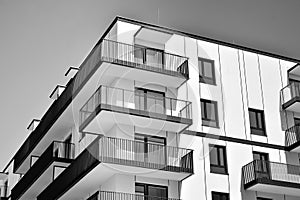 Fragment of a facade of a building with windows and balconies. Black and white.