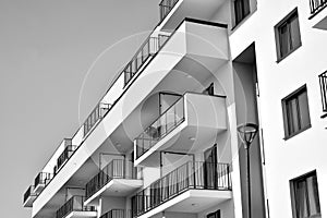 Fragment of a facade of a building with windows and balconies. Black and white.